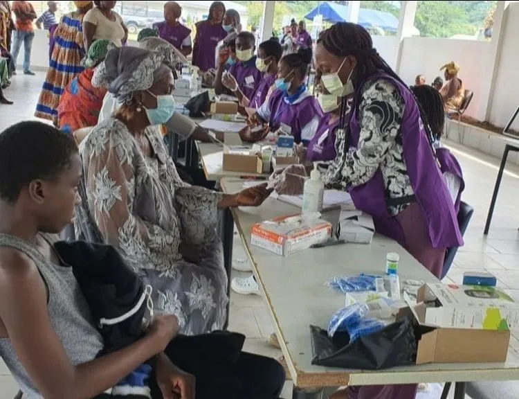 Volunteers working at tables crowded with patients