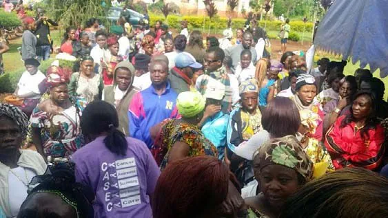 A large crowd waiting to be seen, a volunteer in a purple shirt in front