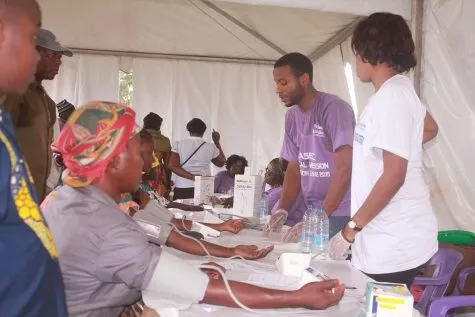 A volunteer measuring a woman's blood pressure