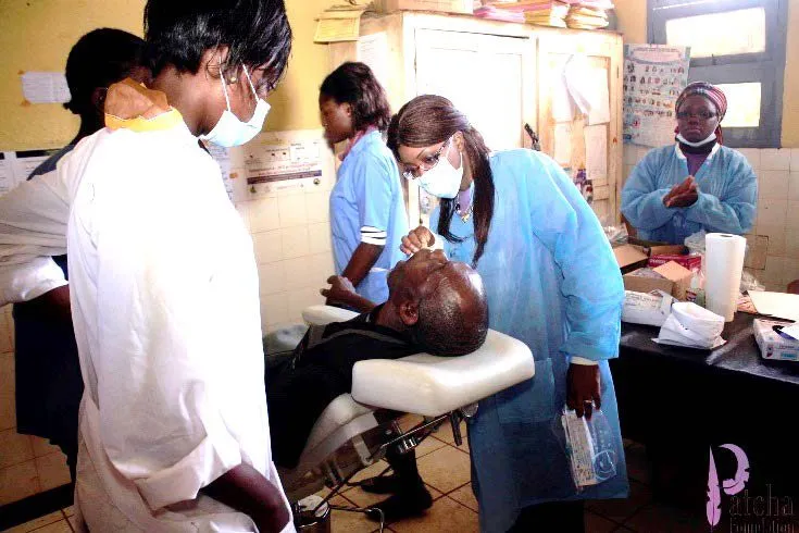 Dental staff in masks treating a patient