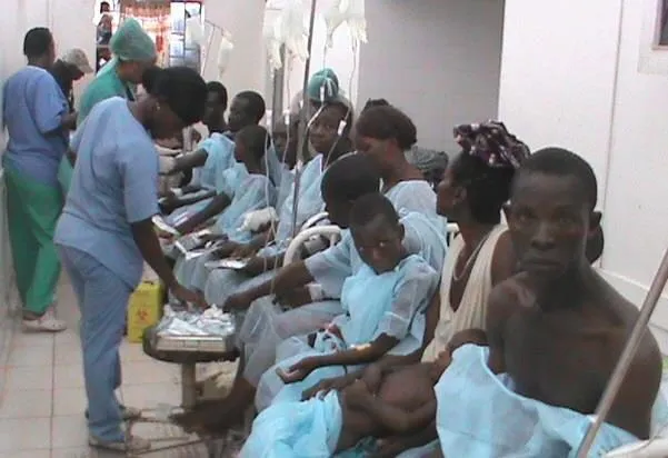 Patients in blue gowns waiting on a ward for surgery