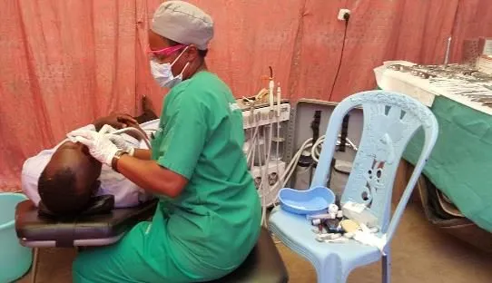 A dental volunteer treating a patient in a dental chair