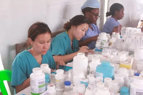 Volunteer pharmacists sorting medicine bottles