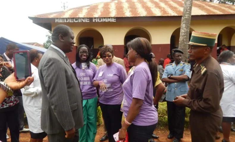Officials in uniform talking with volunteers in purple mission shirts