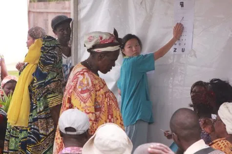 An eye test with a letter chart pinned to a tent wall