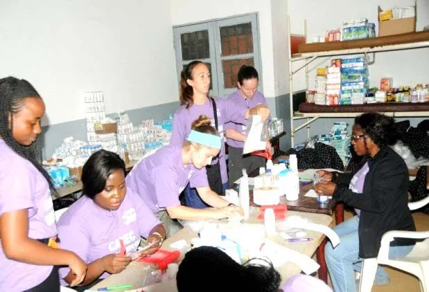 Volunteers in purple shirts working at the pharmacy
