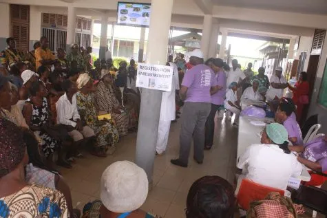A full waiting hall with volunteers moving between patients