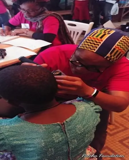 A volunteer examining a patient's ear
