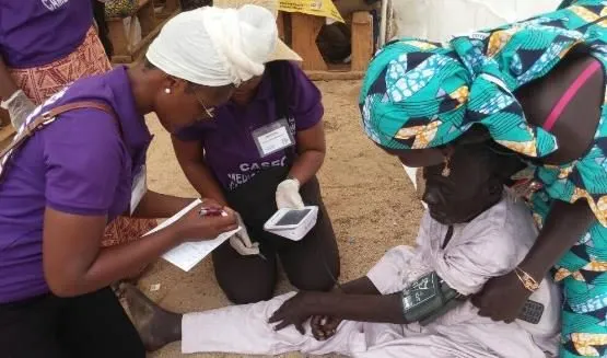 Volunteers helping an elderly man with his forms