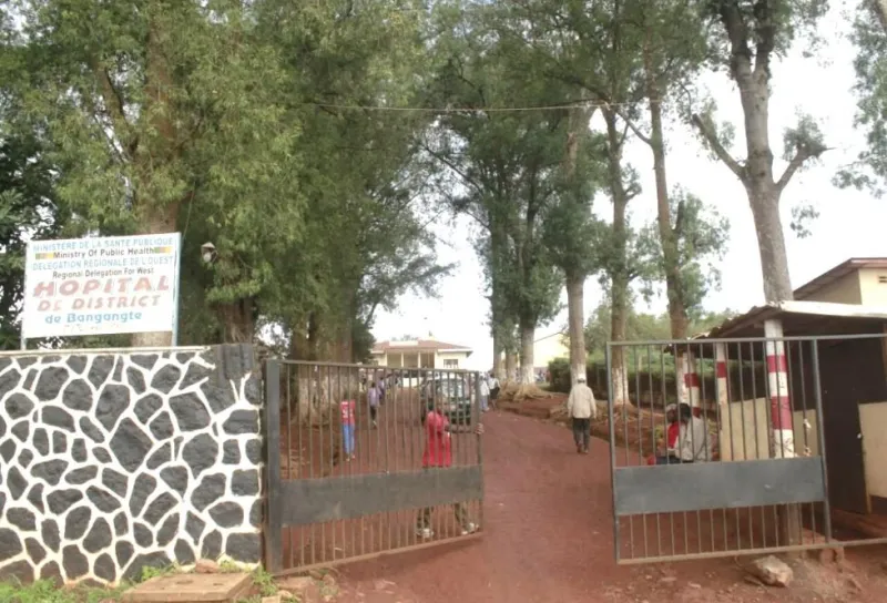 The gate of a district hospital with a sign above it