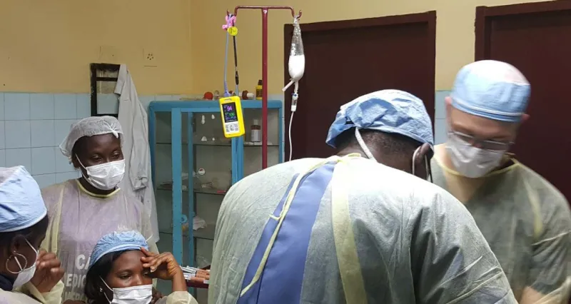 A surgical team in masks and gowns at work