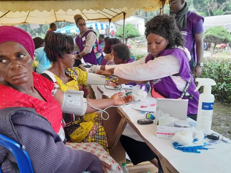 A volunteer checking a woman's blood pressure