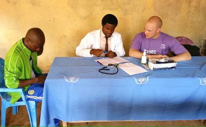 Two volunteers taking a patient's details at a table