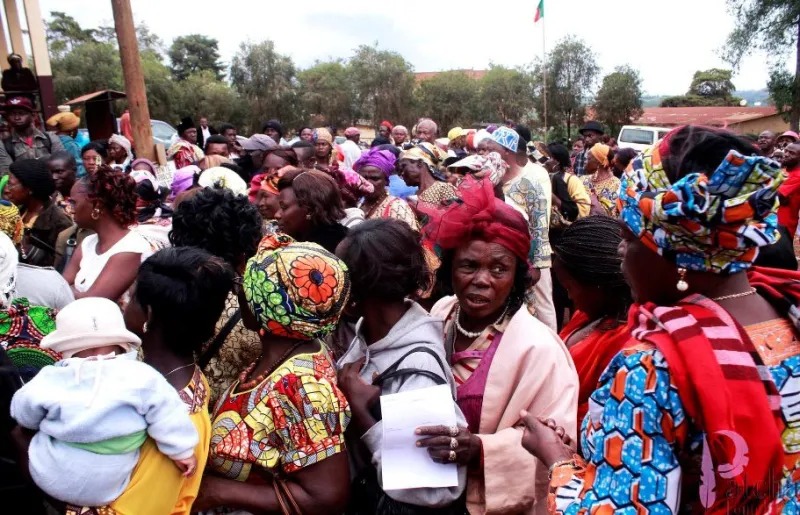Women in colourful dress queueing in a dense crowd